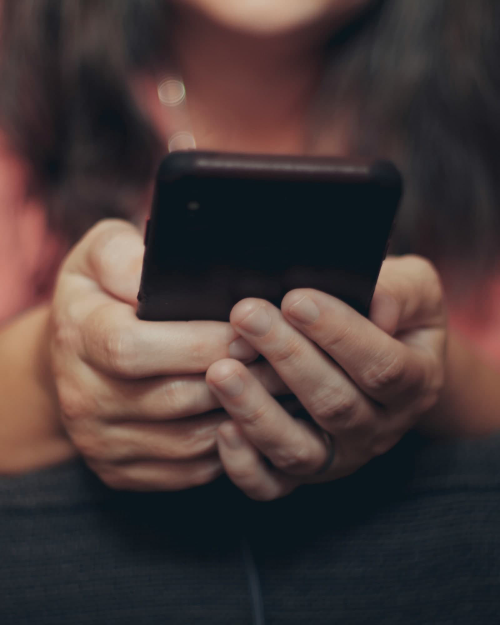 Woman checking her phone in soft morning light, quiet company
